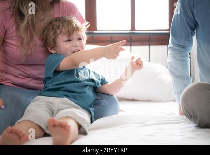 After the little boy wakes up from his nap, his father and mother engage in enjoyable activities in his bedroom. Stock Photo