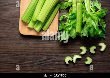 Top view of bunch of fresh sliced celery stalk on wooden table with leaves. Food and ingredients  of healthy vegetable. Freshnes Stock Photo