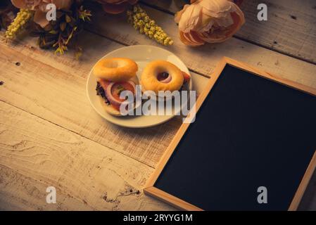 School empty wooden blackboard on wooden floor with hamburger bread and dry flowers. Education and Nature concept. Back to schoo Stock Photo