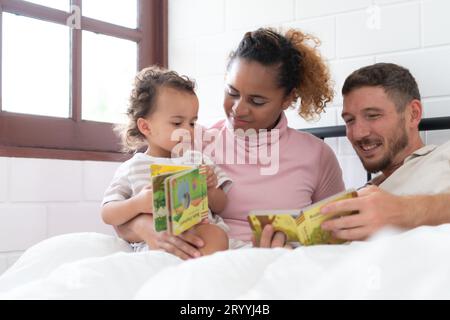 Little girl's father read stories to children before going to bed to unwind and sleep soundly until the morning. Stock Photo