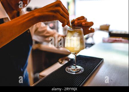 Expert barman is making cocktail at night club. Professional bartender prepare cocktail Stock Photo
