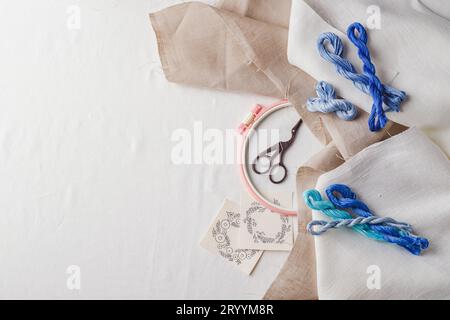 Embroidery set. Linen fabric, embroidery patterns, embroidery hoop, colorful threads and needls. Stock Photo