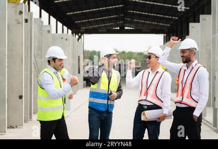Construction engineers, architects, and foremen form a group. Participate in a meeting to plan new construction projects. Cheers Stock Photo