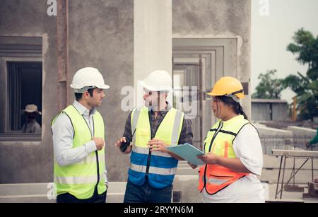 Group of architects, construction foremen, and construction engineers review the work and talk about how the project, in the con Stock Photo