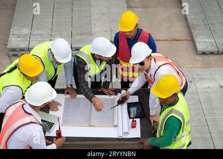 Construction engineers, architects, and foremen form a group. Participate in a meeting to plan new construction projects. Stock Photo