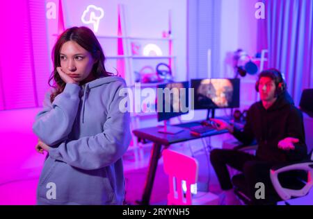 The mood of young ladies who are unsatisfied with their male friends who spend more time playing video games. Stock Photo