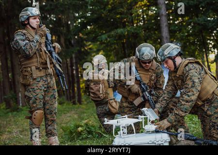 Modern Warfare Soldiers Squad are Using Drone for Scouting and Surveillance During Military Operation in the Forest. Stock Photo