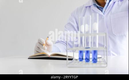 Science innovative Male medical or scientific laboratory researcher performs tests with blue liquid in laboratory. equipment sci Stock Photo