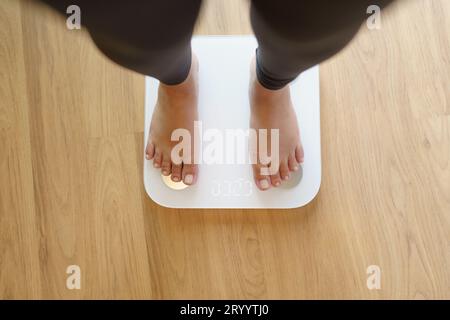 https://l450v.alamy.com/450v/2ryytj0/lose-weight-fat-diet-and-scale-feet-standing-on-electronic-scales-for-weight-control-measurement-instrument-in-kilogram-for-di-2ryytj0.jpg