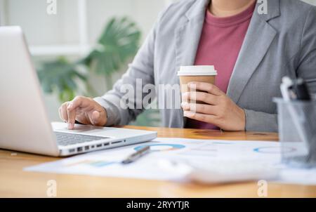 Businesswoman Accountant analyzing investment charts Invoice and pressing calculator buttons over documents. Accounting Bookkeep Stock Photo