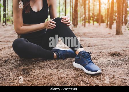 Girl has sport accident injury in forest at outdoors. Healthy and Medicine concept. Adventure and Travel concept. Pine woods the Stock Photo