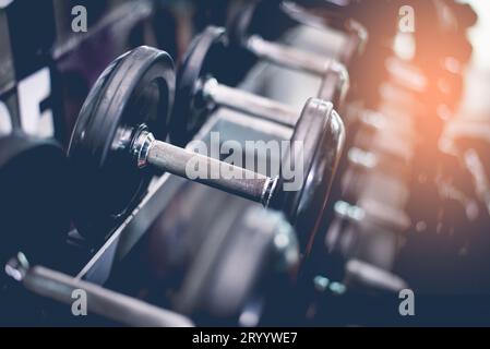 Black steel dumbbell set. Close up of dumbbells on rack in sport fitness center. Workout training and fitness gym concept. Healt Stock Photo