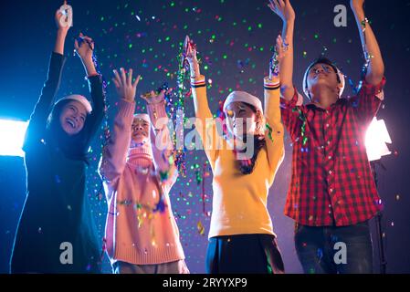 Group of Asian people celebrating New year party in night club with confetti. New year and Christmas party concept. Happiness an Stock Photo