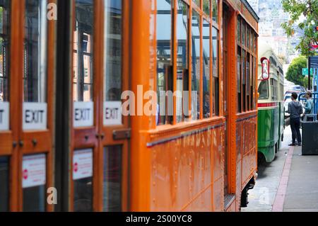 San Francisco, CA, USA. April 22, 2012: Historic streetcars in vibrant colors line up on urban tracks. Stock Photo