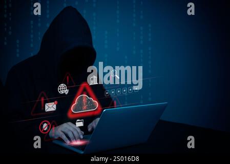 Hooded figure at laptop with cybersecurity alert icons, symbolizing hacking threats, data breaches, and online crime. Ideal for cybersecurity concepts Stock Photo