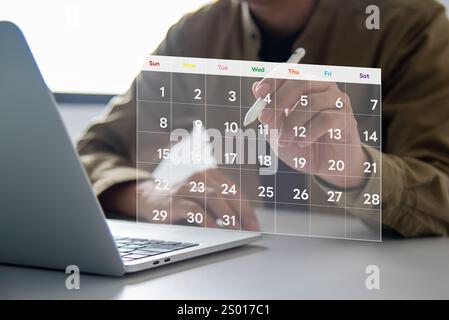 Hand using a holographic calendar interface for scheduling tasks and events on a laptop. Represents time management, organization, and future tech. Stock Photo