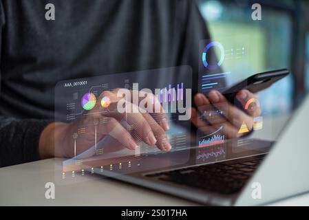 Hands analyzing data digital dashboards with charts and graphs on a laptop and smartphone. KPI key performance indicators and reports management analy Stock Photo