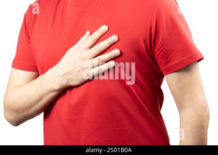 A man wearing a red T-shirt is shown holding his chest with one hand, expressing discomfort or pain. Stock Photo