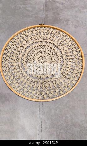 Crochet napkin on a wooden frame. Mandala with different patterns Decor Handmade Wooden background Stock Photo