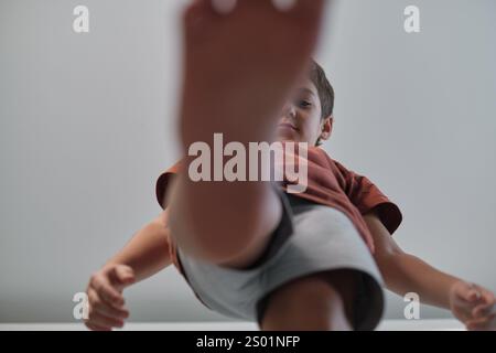 A child steps forward with one foot close to the camera, captured from a unique low-angle perspective. This photo reflects playful exploration and an Stock Photo