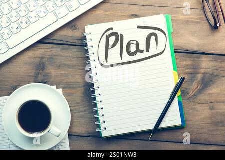Plan text on notepad and keyboard and coffee on table Stock Photo