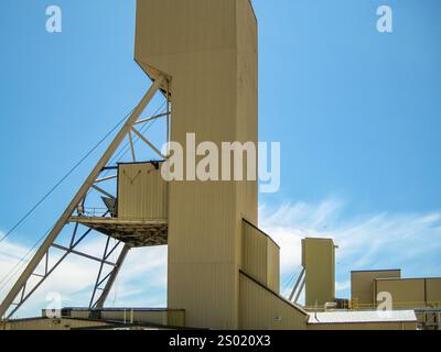 A large building with a ladder on the side. The building is brown and has a large number 1 on it. The sky is blue and clear Stock Photo