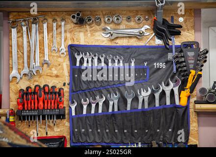 Background with wall with spanners of all sizes, screwdrivers, pliers and other special tools in the garage Stock Photo