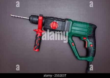 Hammer drill with handle on a working table. Stock Photo