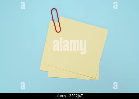 Blank note with green paper clip isolated on blue. Sticky notes png texture pin memo reminder. Use notes to share idea on sticky note. Stock Photo