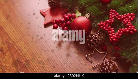 Image of spots of light floating over christmas decorations on wooden surface. Christmas festivity and celebration concept Stock Photo