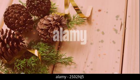 This image features warm, glowing orange and yellow spots floating on a black background. Christmas decorations such as pine cones and lights are also Stock Photo