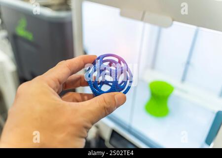 hand with hollow sphere object printed on 3d printer close-up Stock Photo