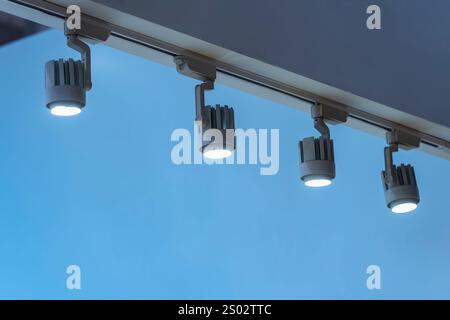 Directional LED lights on rails under the ceiling in a modern warehouse, shopping center building, office or other commercial real estate object. Stock Photo