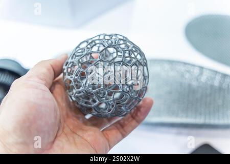 hand with hollow sphere object printed on 3d printer close-up Stock Photo