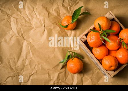 Top view of freshly picked organic tangerines in a wooden crate. Tangerine box Stock Photo