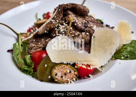 A fresh salad with grilled steak, parmesan shavings, capers, and cherry tomatoes. Stock Photo