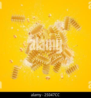 Radiatori pasta exploding with flour and whole wheat grains on yellow background Stock Photo