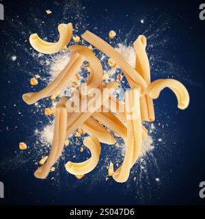 Caserecce pasta pieces exploding with flour and whole wheat grains on a blue background Stock Photo