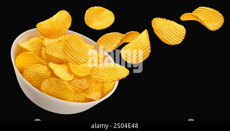 Falling ridged potato chips in bowl isolated on black background Stock Photo