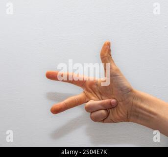 single hand showing three fingers against a white background, symbolizing counting, options, or the number three in various contexts Stock Photo