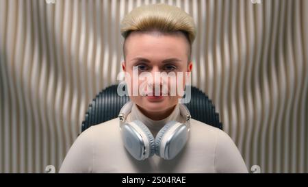 Close up woman Caucasian girl serious female lady student businesswoman influencer cyber gamer listen music wear earphones audio device listening song Stock Photo