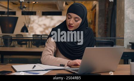 Muslim woman in hijab female worker freelancer student Arabian businesswoman employee office manager agent online laptop remote work at workplace Stock Photo