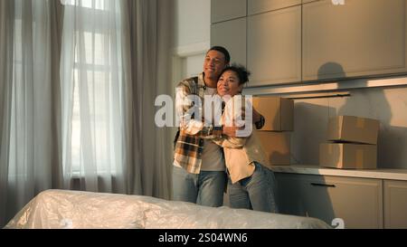 African American family happy affectionate couple home owners renters man woman moving in new apartment relocation buying house joyful male female Stock Photo