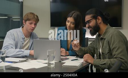Company teamwork at office desk talk planning discuss online project laptop multiethnic business team men women colleagues male female Indian Stock Photo