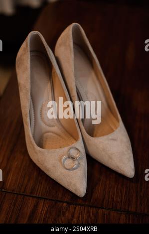Elegant Beige High Heels with Wedding Rings. Stock Photo