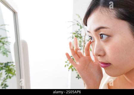 Young woman taking care of her skin in her room Stock Photo