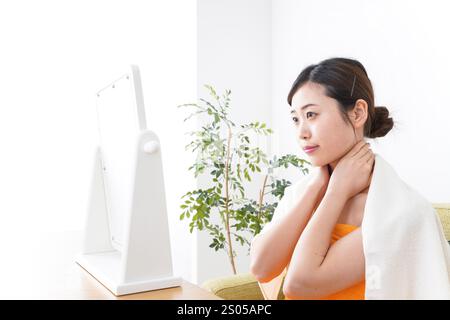 Young woman taking care of her skin in her room Stock Photo