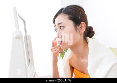 Young woman taking care of her skin in her room Stock Photo