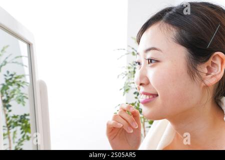 Young woman taking care of her skin in her room Stock Photo