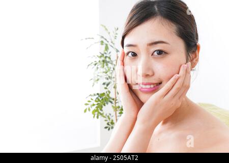 Young woman taking care of her skin in her room Stock Photo